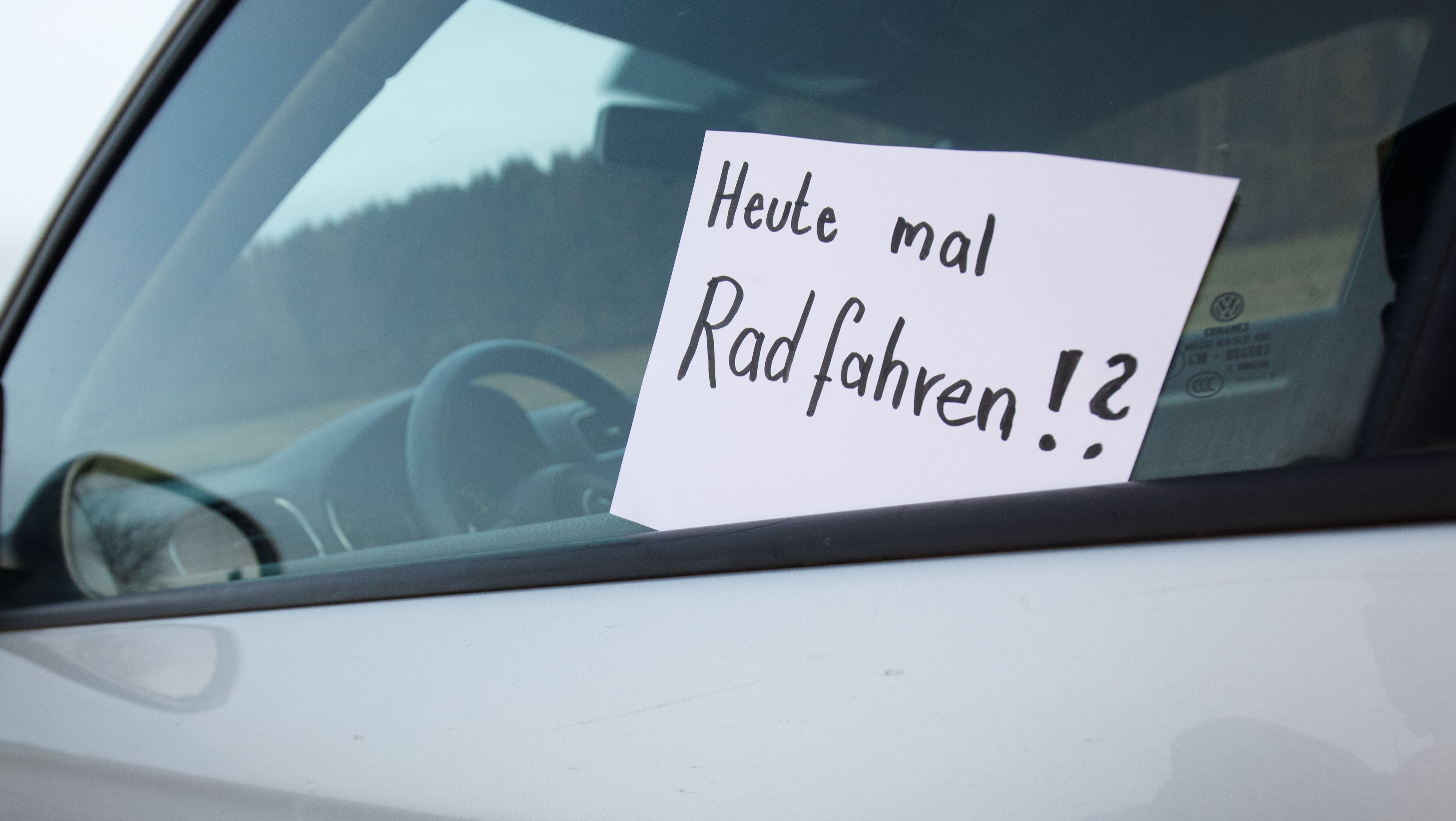 Zettel auf einem Autofenster: "Heute mal Radfahren?"